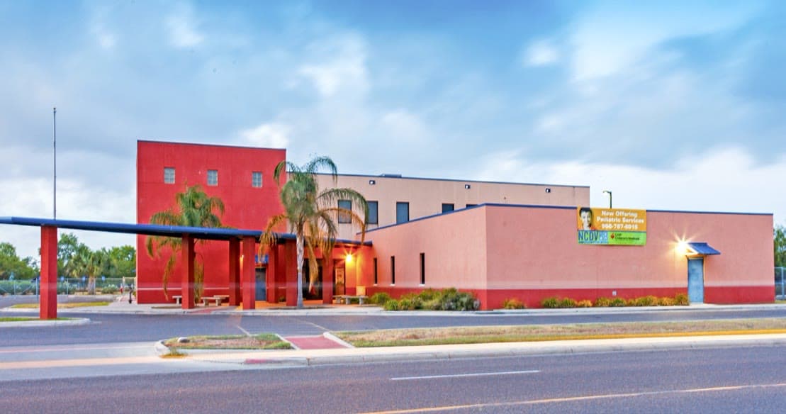 The front of the San Juan Clinic, a two-story terracotta and tan building with a covered entrance
